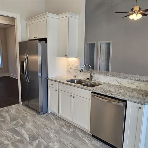 a kitchen with stainless steel appliances granite countertop a refrigerator and a sink