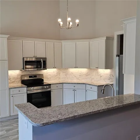 a kitchen with granite countertop a sink and a stove