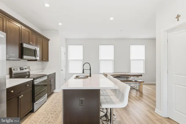 a kitchen with stainless steel appliances a sink stove and cabinets
