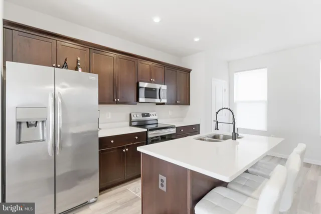 a kitchen with stainless steel appliances a refrigerator sink and microwave