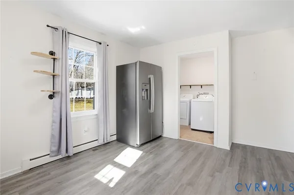 a view of empty room with wooden floor and window