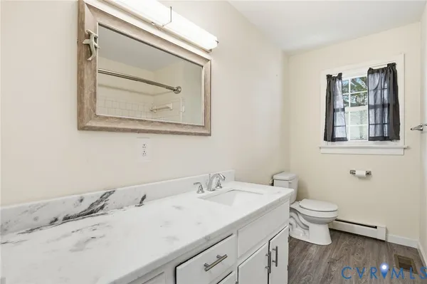 a bathroom with a granite countertop sink and a toilet