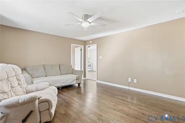 a living room with furniture and a ceiling fan