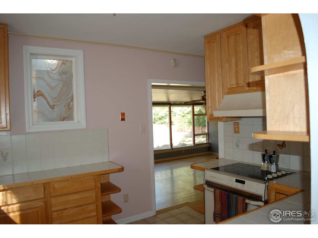 2447 20th Street Boulder, CO 80304 - Photo 9 of 12 a kitchen with kitchen island wooden cabinets a stove a sink and a window
