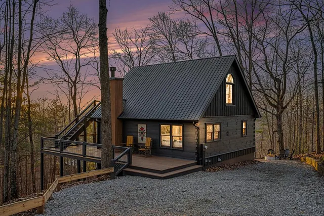 a backyard of a house with large trees and wooden fence