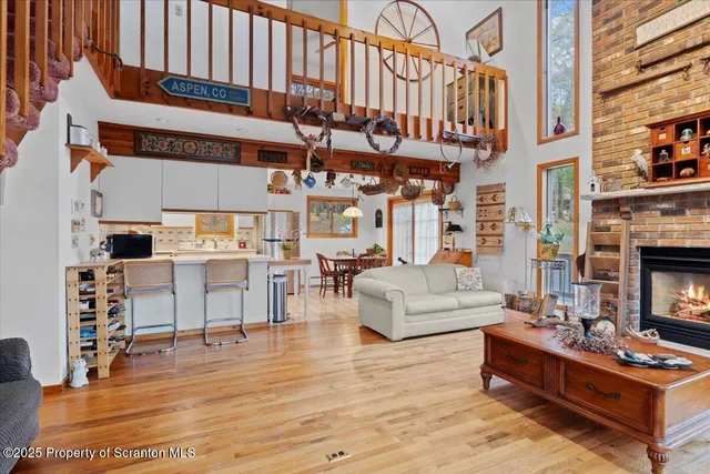 a living room with furniture a fireplace and a dining table with wooden floor