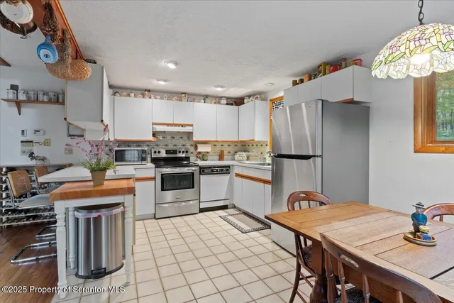 a kitchen with a table chairs sink and refrigerator