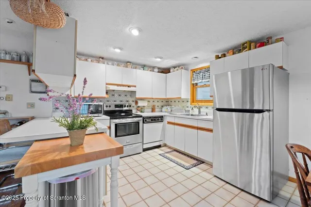 a kitchen with granite countertop stainless steel appliances and refrigerator