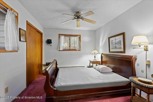 a bedroom with a bed wall painting and a window
