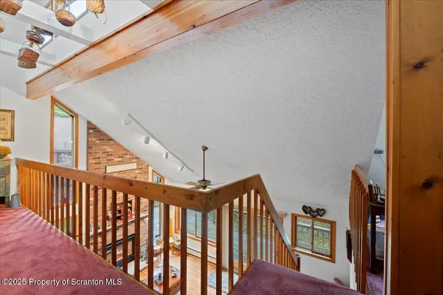 a view of staircase with lots of frames on wall and a large window