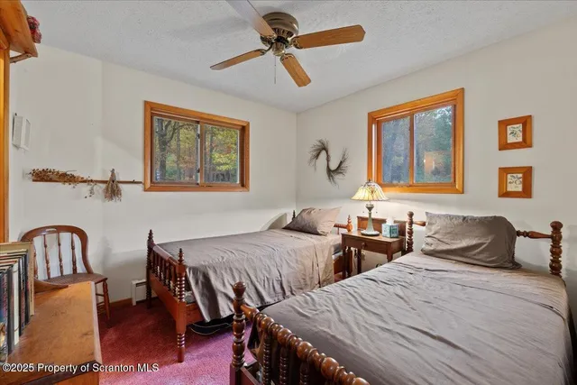 a bedroom with two beds and painting on the wall
