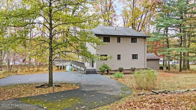 a view of a white house next to a road and yard