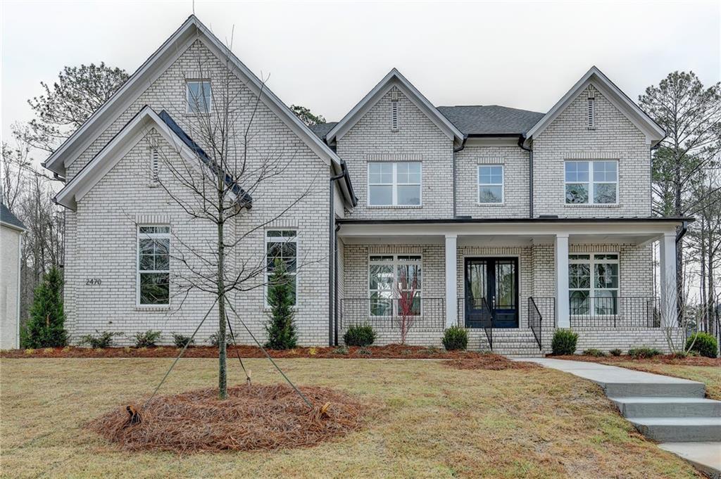 2470 Stewart Road Cumming, GA 30041 - Photo 1 of 61 a view of a white house with a small yard and plants