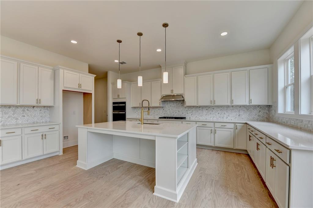 2470 Stewart Road Cumming, GA 30041 - Photo 18 of 61 a kitchen with stainless steel appliances kitchen island granite countertop a stove a sink and a refrigerator