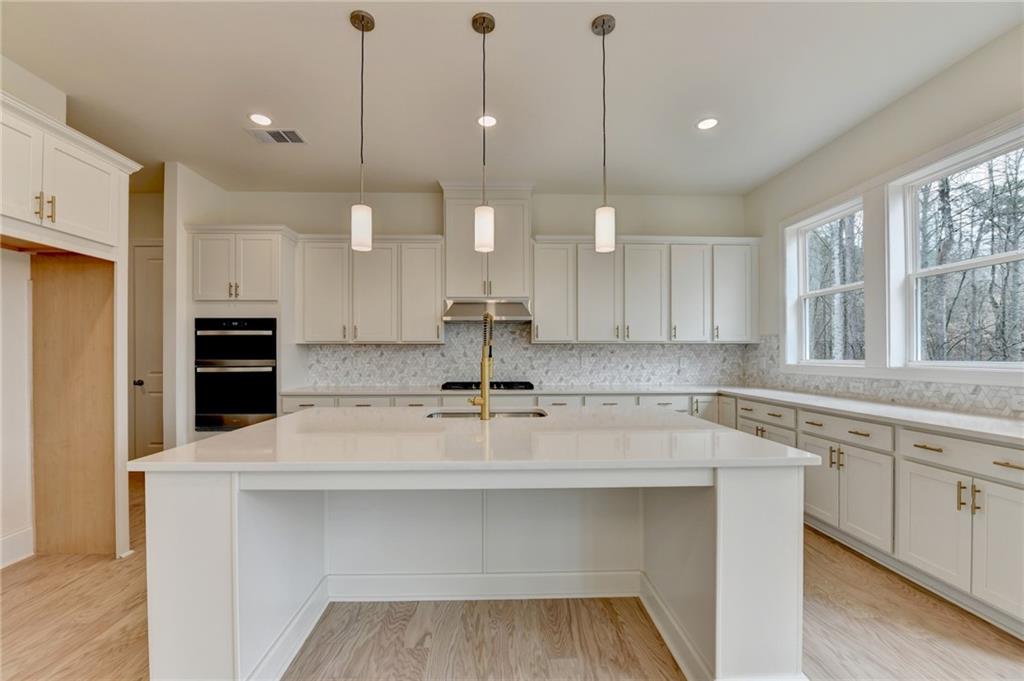 2470 Stewart Road Cumming, GA 30041 - Photo 20 of 61 a kitchen with kitchen island a sink stainless steel appliances and cabinets