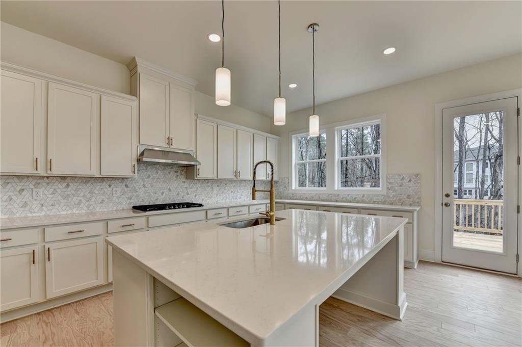 2470 Stewart Road Cumming, GA 30041 - Photo 21 of 61 a kitchen with stainless steel appliances granite countertop a sink a stove and a wooden floors