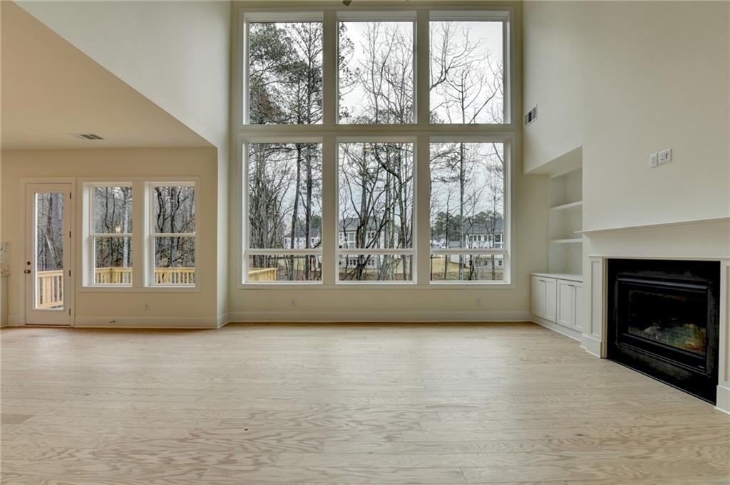 2470 Stewart Road Cumming, GA 30041 - Photo 25 of 61 a view of an empty room with a fireplace and a window