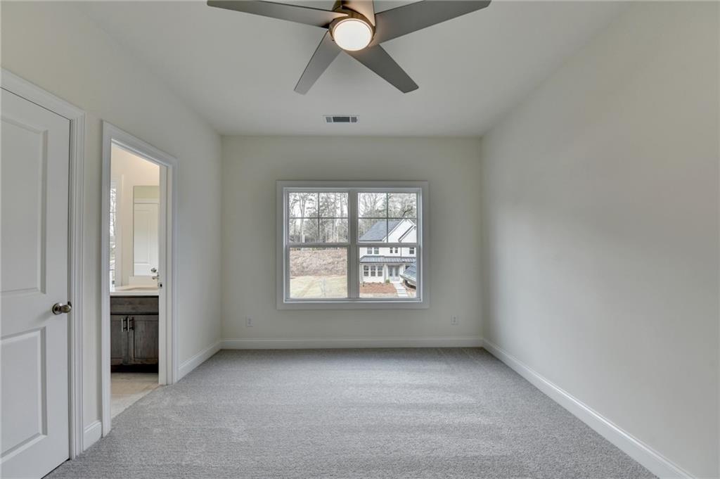 2470 Stewart Road Cumming, GA 30041 - Photo 39 of 61 an empty room with chandelier fan and windows