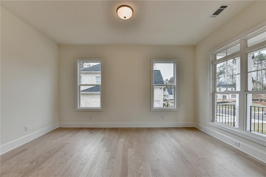 2470 Stewart Road Cumming, GA 30041 - Photo 9 of 61 a view of an empty room with a window and wooden floor