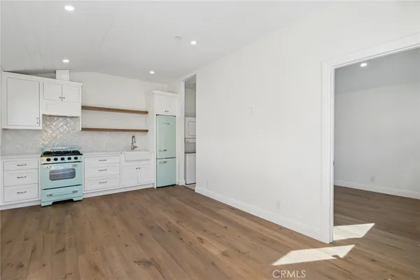 a kitchen with stainless steel appliances a stove and white cabinets