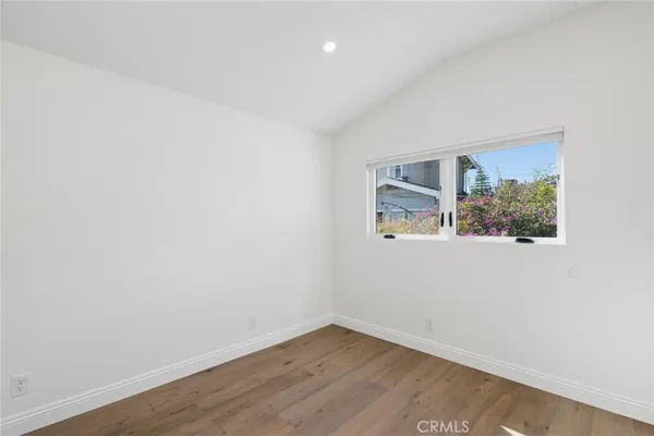 a kitchen with cabinets wooden floor and a window