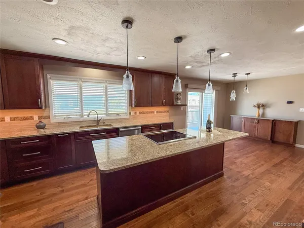 a large kitchen with a counter space a sink appliances and cabinets