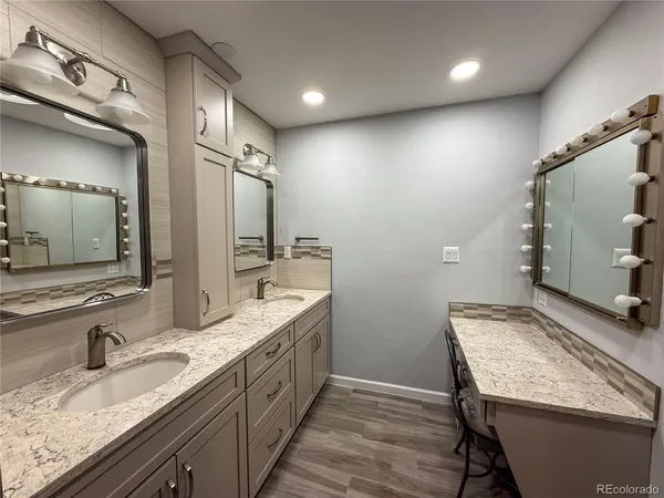 a bathroom with a granite countertop sink and a mirror