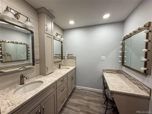a bathroom with a granite countertop sink and a mirror