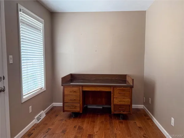 a room with wooden floor and a window
