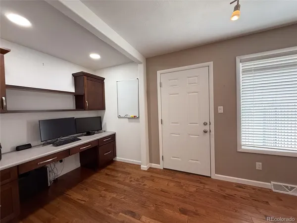 a view of a workspace with furniture and a window