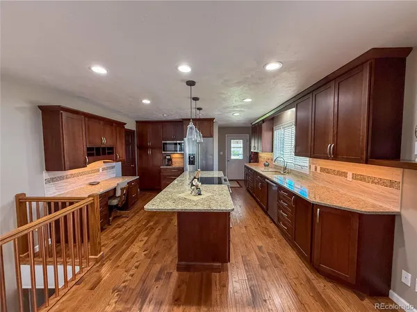 a large kitchen with stainless steel appliances kitchen island granite countertop a large stove a oven a large island with the wooden floor
