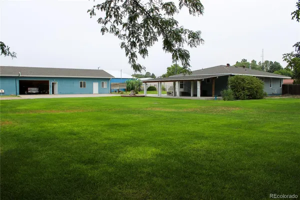 a front view of a house with a yard and trees