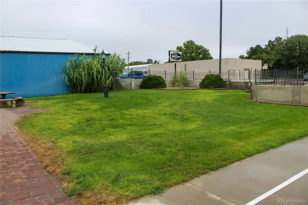 a view of house with a yard and large tree