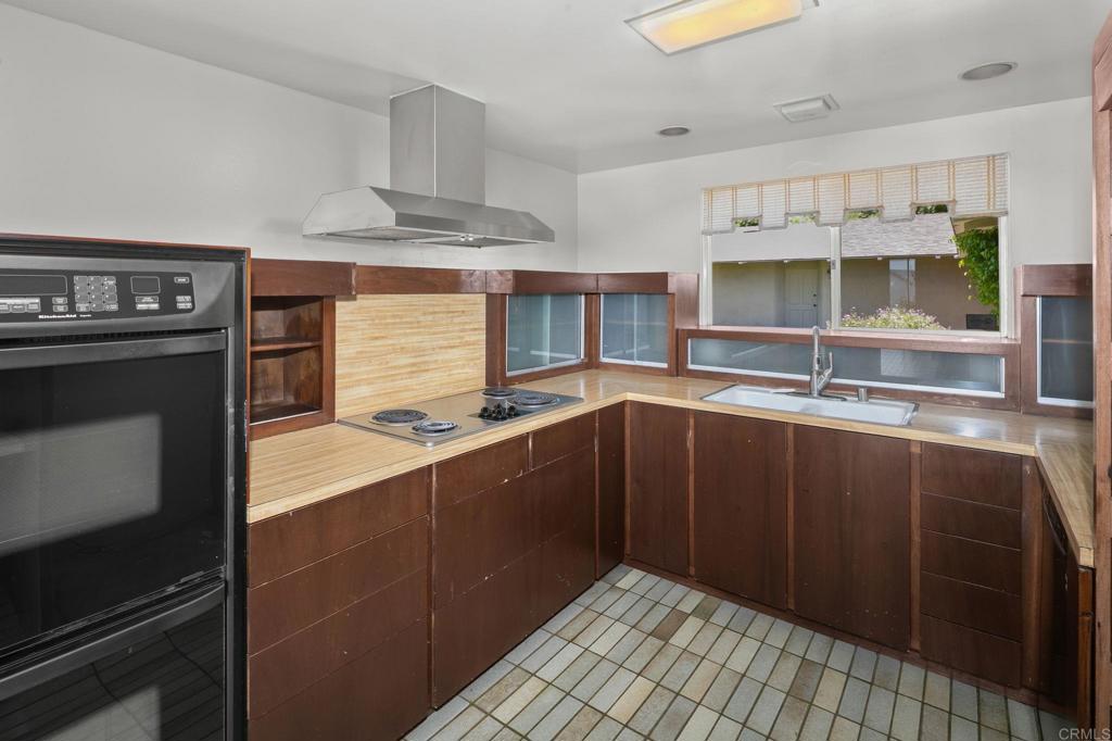 14048 San Pasqual Valley Road Escondido, CA 92027 - Photo 21 of 55 a kitchen with stainless steel appliances a sink stove and cabinets