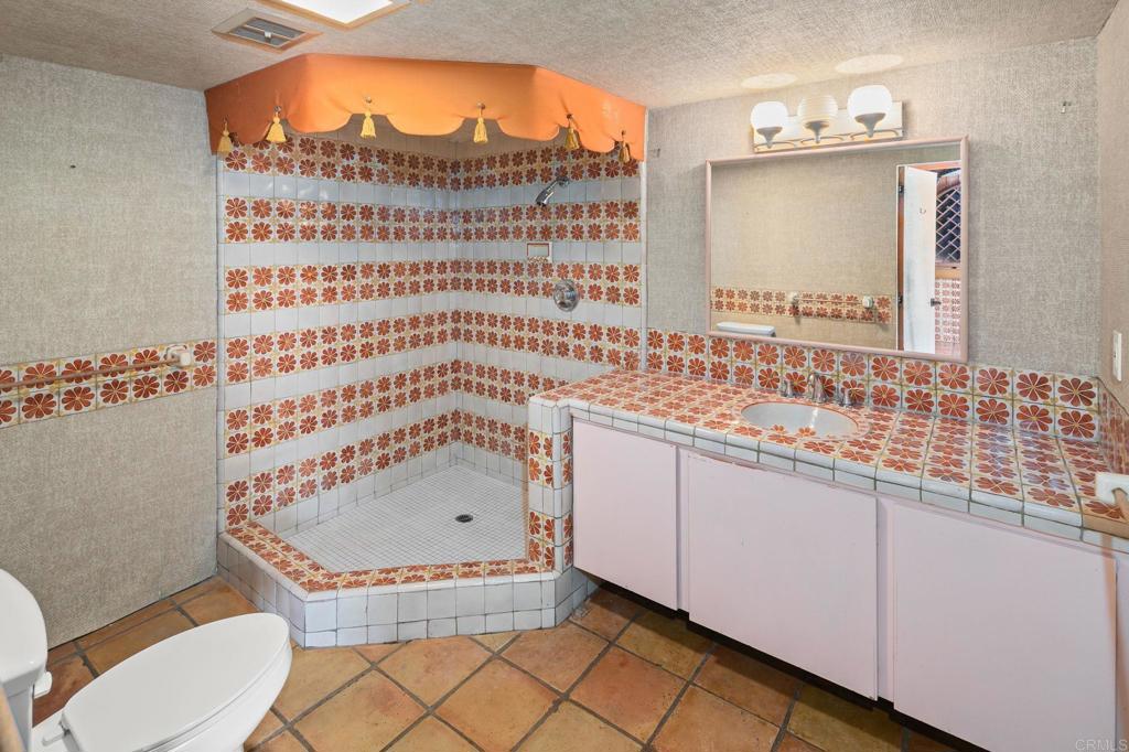 14048 San Pasqual Valley Road Escondido, CA 92027 - Photo 46 of 55 a bathroom with a sink a mirror and a bathtub