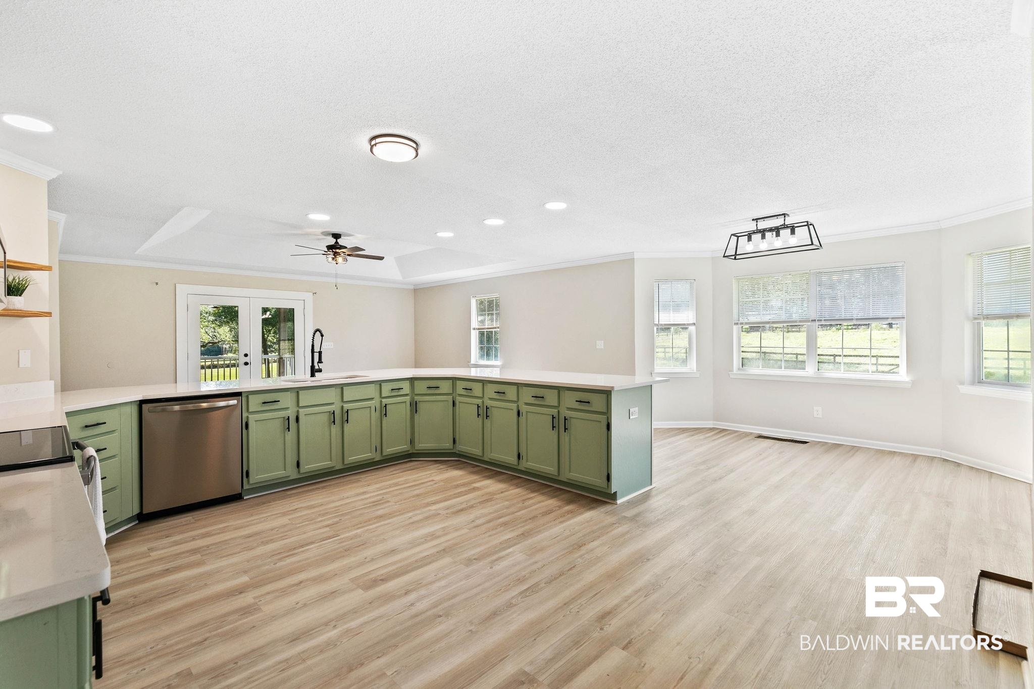 35650 Spring Road North Stapleton, AL 36578 - Photo 11 of 70 Kitchen featuring green cabinetry, a raised ceiling, light wood-style flooring, light stone counters, and ornamental molding