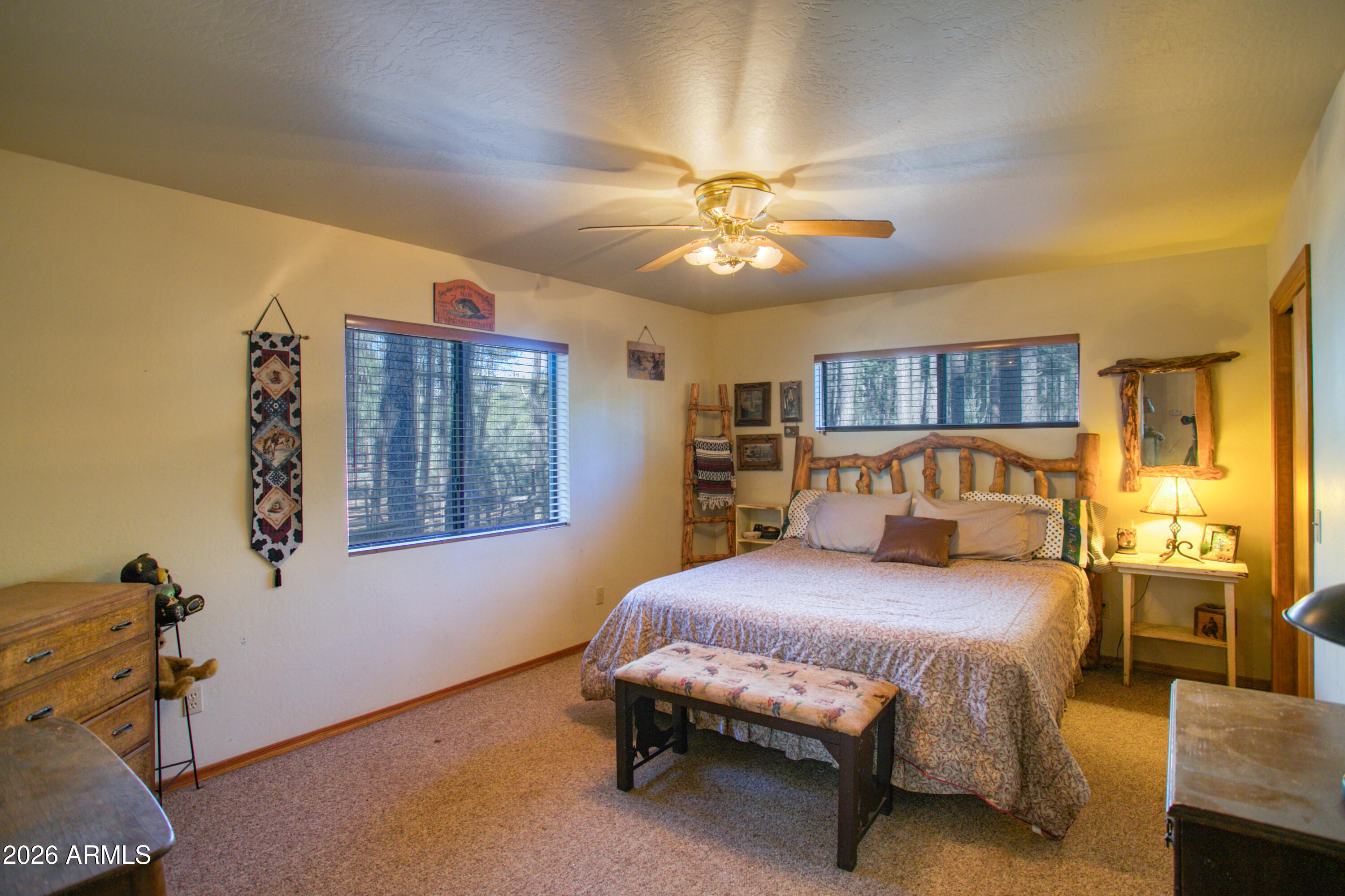 146 Deer Run Road Pinetop, AZ 85935 - Photo 12 of 44 a bedroom with a bed and a chandelier