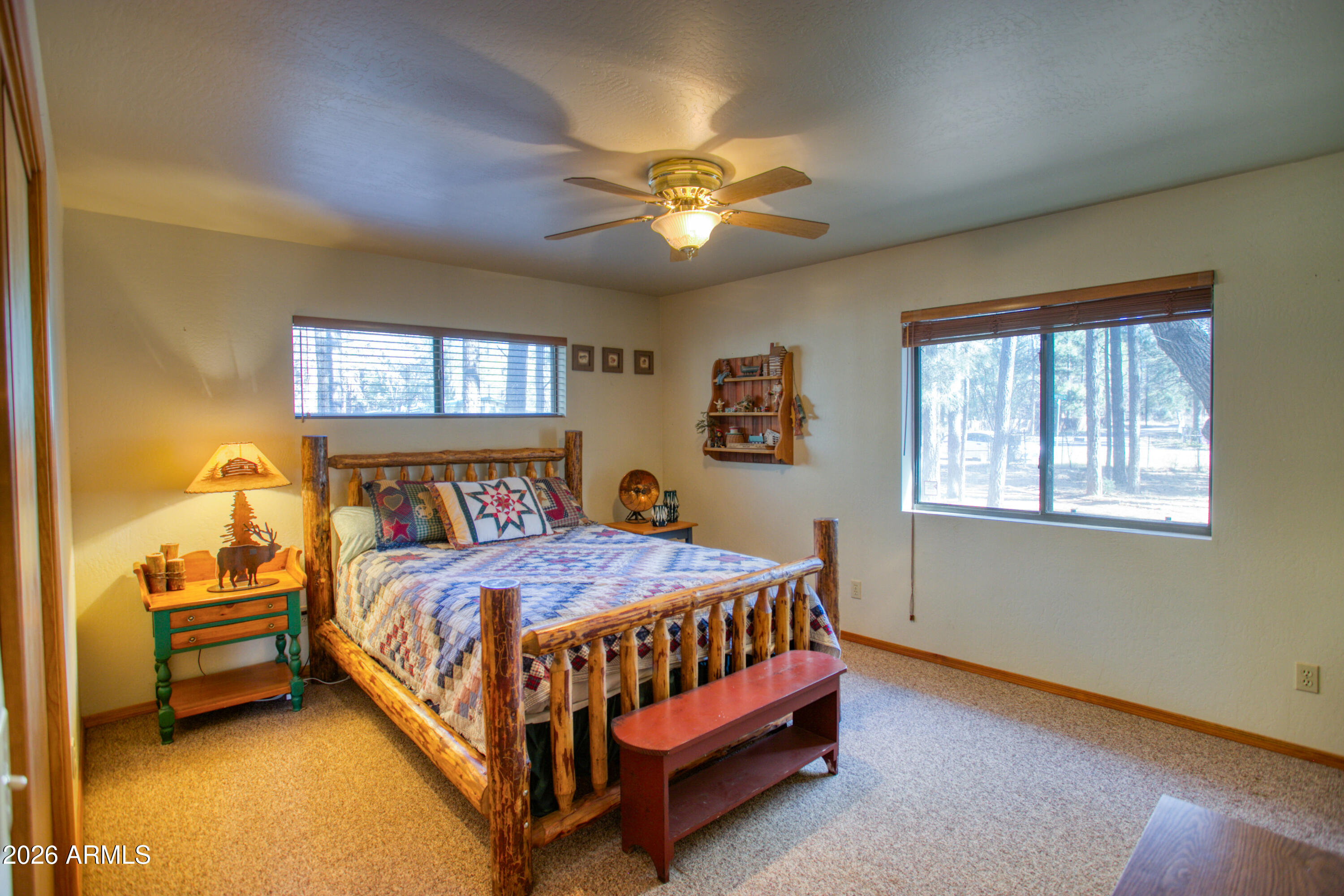 146 Deer Run Road Pinetop, AZ 85935 - Photo 15 of 44 a bedroom with a bed and a chandelier