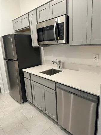 a kitchen with stainless steel appliances a refrigerator sink and microwave