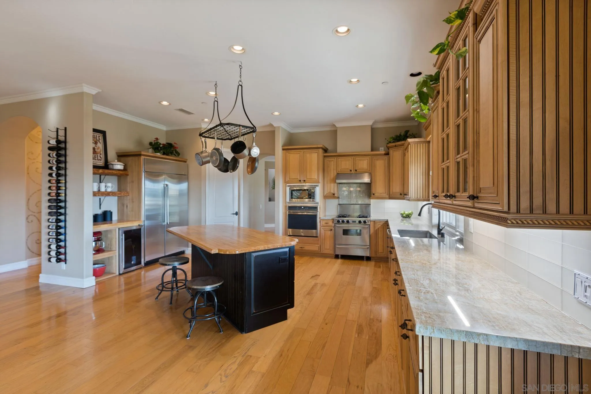 30419 Canyon Estates Road Vista, CA 92084 - Photo 19 of 75 a dining hall with stainless steel appliances granite countertop a refrigerator a sink a dining table and chairs with wooden floor
