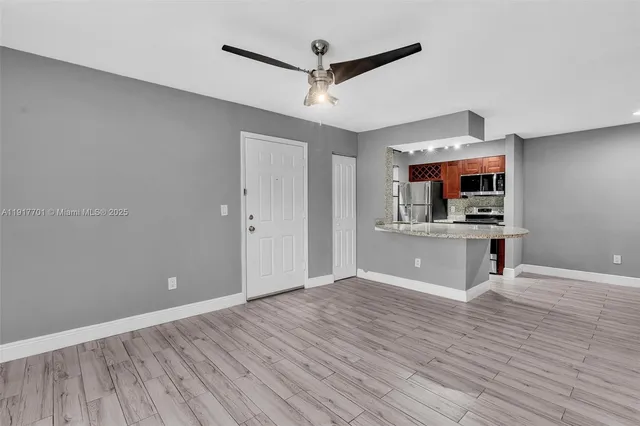 a view of a kitchen with wooden floor and a ceiling fan