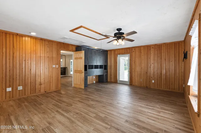 a view of an empty room with window and wooden floor