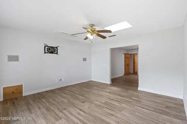 a view of a room with wooden floor and a ceiling fan