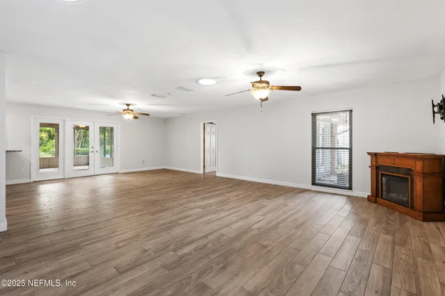 an empty room with windows and fireplace