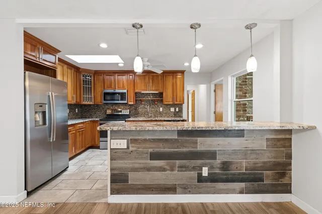 a kitchen with stainless steel appliances granite countertop a refrigerator a oven and a stove