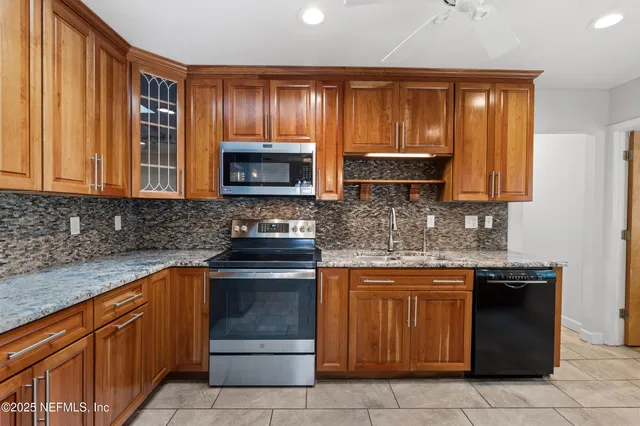 a kitchen with stainless steel appliances granite countertop wooden cabinets and a stove top oven
