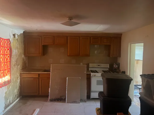 a kitchen with a refrigerator and a stove top oven