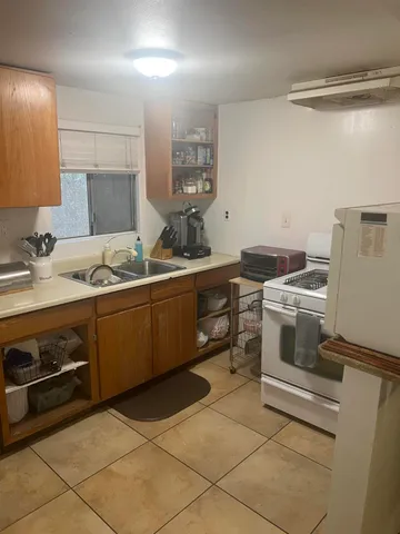 a kitchen with a stove sink and cabinets