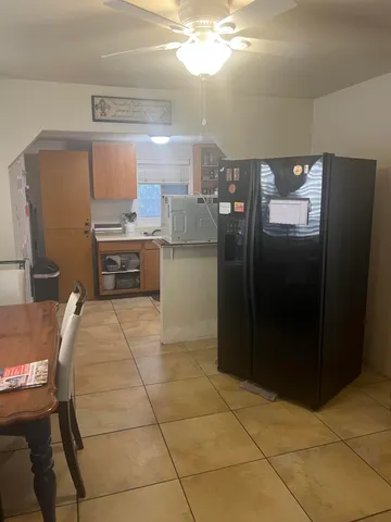 a kitchen with granite countertop a refrigerator and a stove top oven