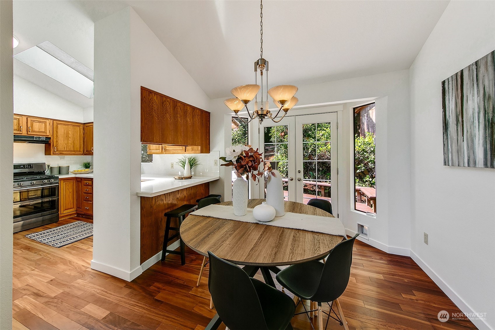 21822 4th Avenue Southeast Bothell, WA 98021 - Photo 4 of 40 a dining room with wooden floor a chandelier a wooden table and chairs